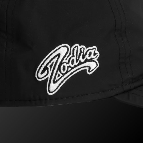 Close-up of Zodia waterproof rain cap featuring embroidered logo on a black nylon fabric.