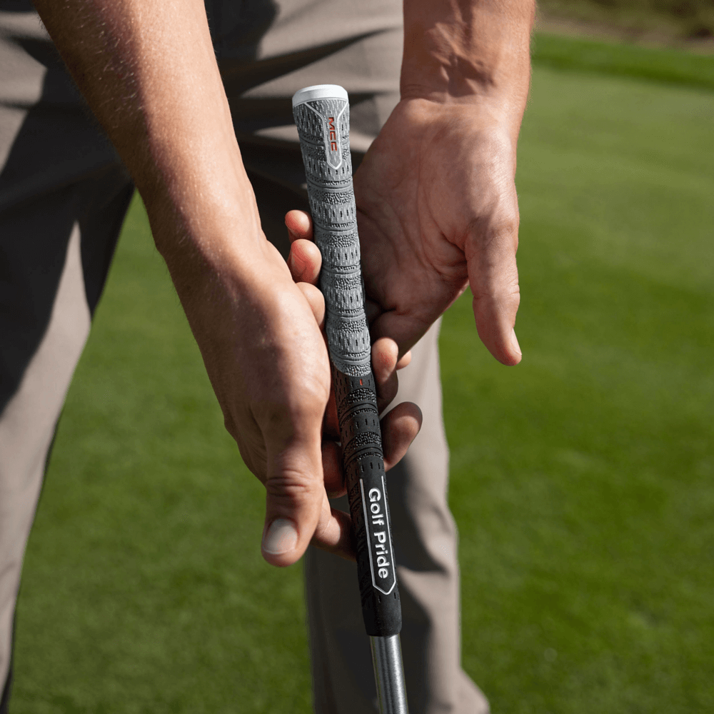 Close-up of a golfer's hands gripping the Golf Pride MCC Align Max hybrid grip on a golf club.