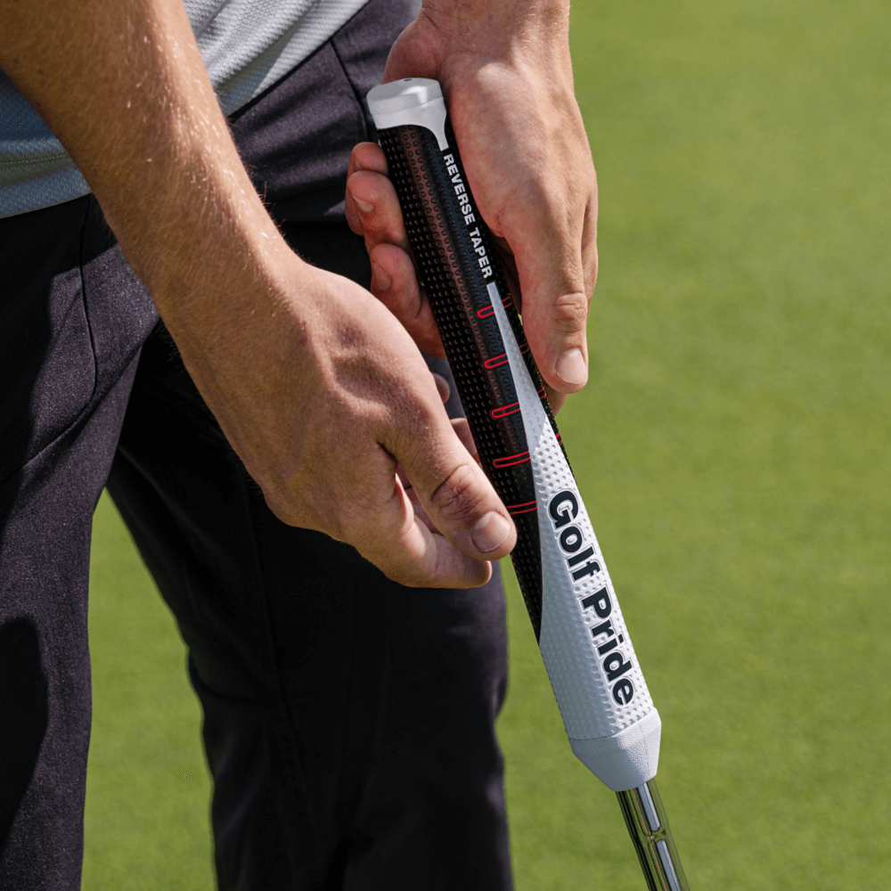 Close-up of a golfer gripping the Golf Pride Reverse Taper putter grip, showcasing its modern design and flat shape.