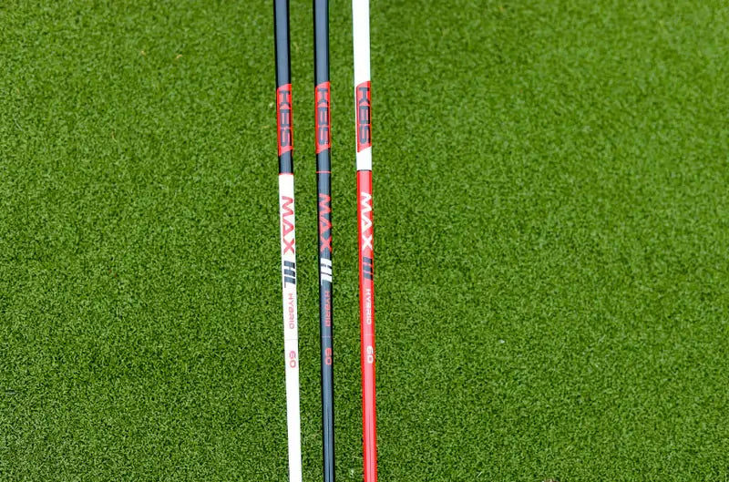 KBS MAX HL Hybrid shafts displayed on green turf, showcasing the graphite design for enhancing game performance.