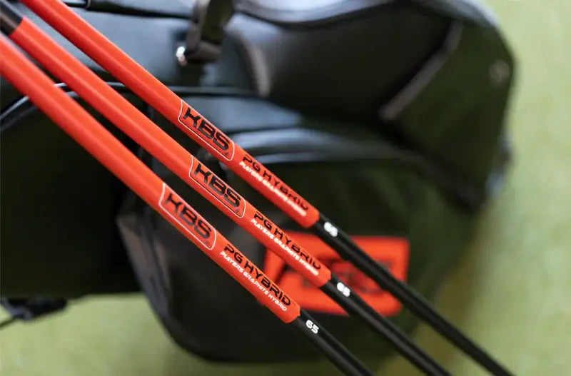 KBS PGH graphite hybrid shafts resting on a golf bag, showcasing their vibrant design and performance features.