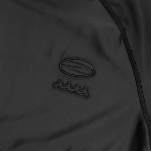 Close-up of Zodia muta mock neck shirt showcasing unique logo design in black on soft fabric.