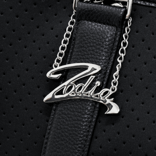 Close-up of Zodia tote bag handle featuring silver logo charm on textured black fabric.