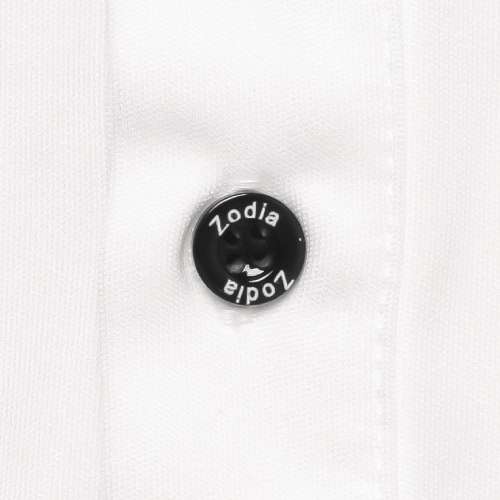 Close-up of Zodia logo button on a white polo shirt, showcasing quality and stylish design details.