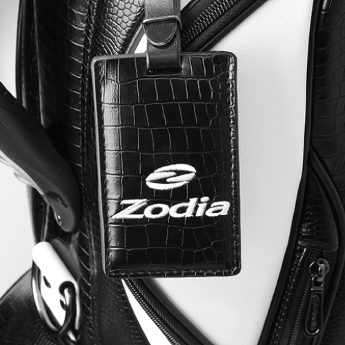 Close-up of Zodia caddie bag luggage tag featuring a caiman pattern and branded logo.