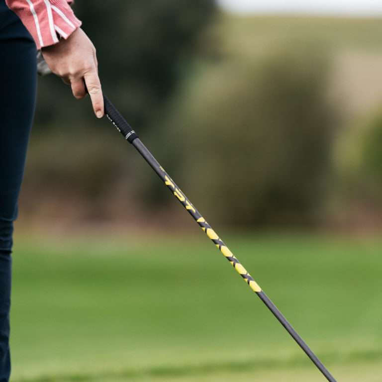 Golfer holding TPT Power Range Fairway Wood Shaft with yellow and black detailing on the course.