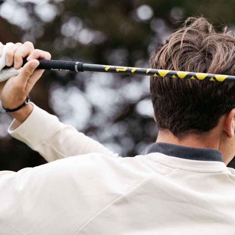 Golfer preparing to tee off with the TPT Power Range Hybrid Shaft, showcasing its design and grip.