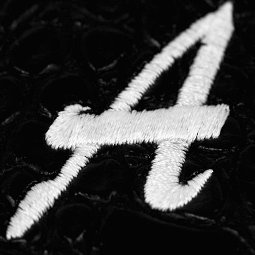 Close-up of a white embroidered number 4 on a textured black background.