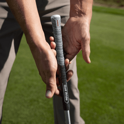 Close-up of a golfer's hands gripping the Golf Pride MCC Align Max hybrid grip on a golf club.