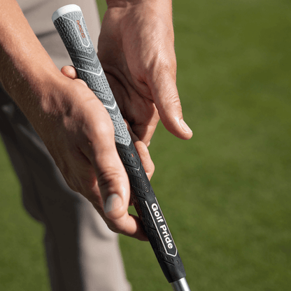 Golfer holding Golf Pride MCC Plus4 ALIGN MAX grip, showcasing its innovative design and raised ridge technology.
