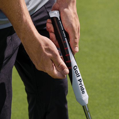 Close-up of a golfer gripping the Golf Pride Reverse Taper putter grip, showcasing its modern design and flat shape.
