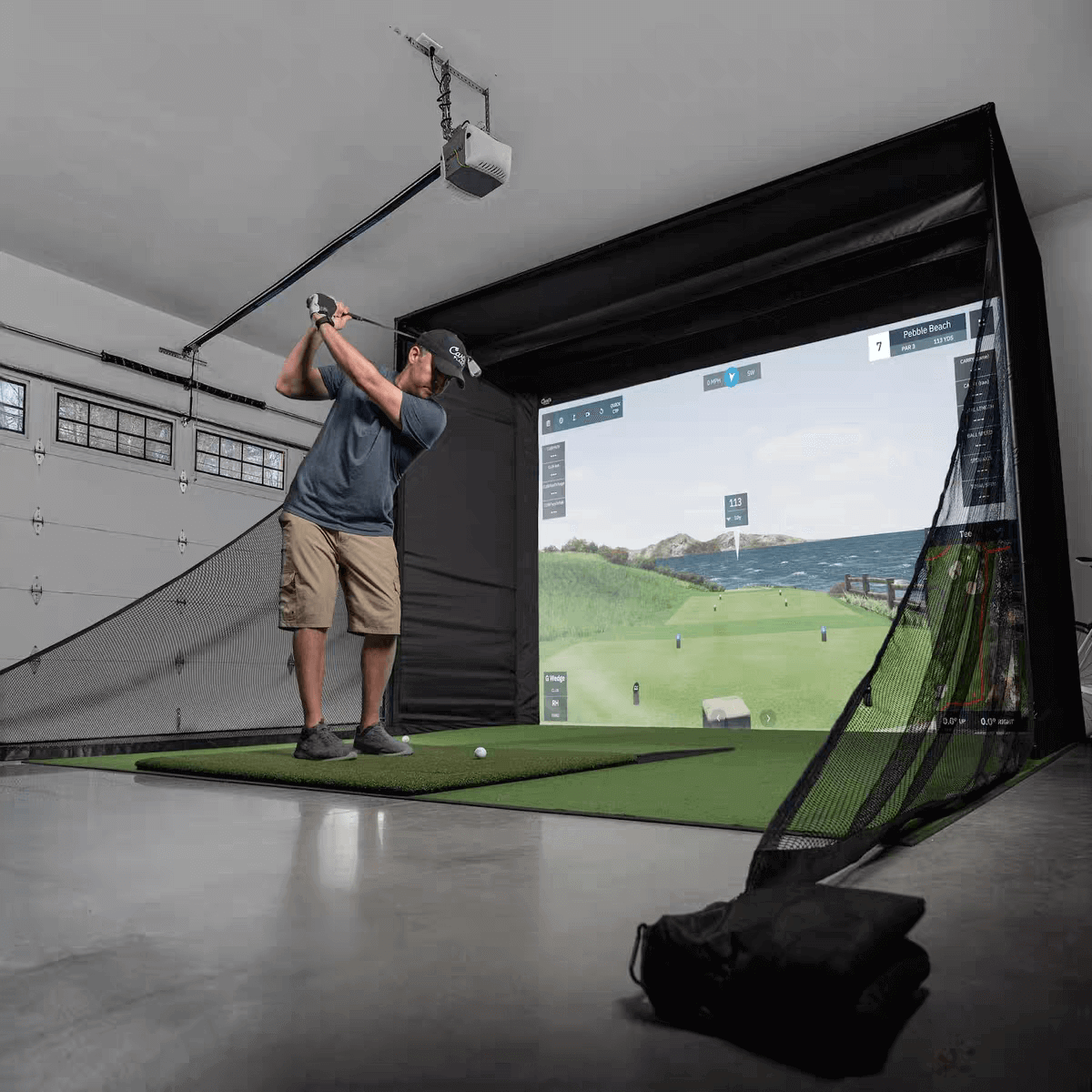 A golfer swinging in a golf simulator setup, showcasing the Golf Simulator Value Package with realistic visuals.