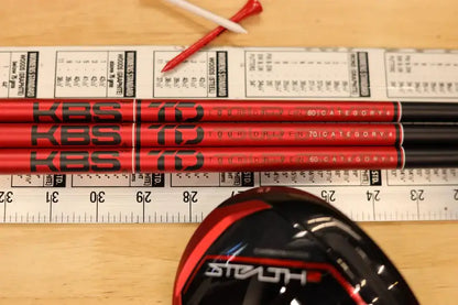 KBS TD Driver/Wood shafts on a table with a golf club head, showcasing performance-driven design and technology.
