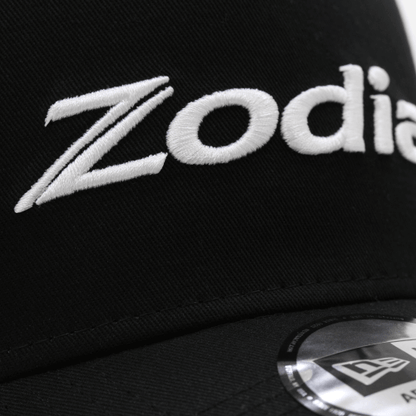Zodia Metal Badge Cap featuring embroidered logo on a black cotton base, showcasing stylish design details.