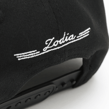 Black cap detail showing 'Zodia' embroidered logo on the back, emphasizing stylish design and adjustable fit.