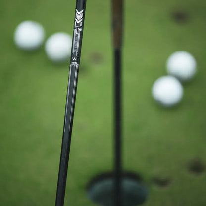 Mitsubishi MMT Scoring Wedge close-up, showcasing Metal Mesh Technology shaft with golf balls in the background.