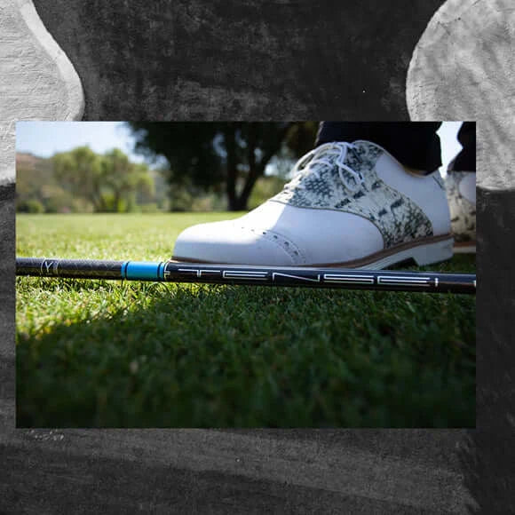 Close-up of Mitsubishi TENSEI 1K Pro Blue wood shaft and golf shoe on grass.