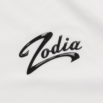 Zodia logo in glossy black on a white fabric, showcasing brand identity for the Zodia Splash Polo Shirt.