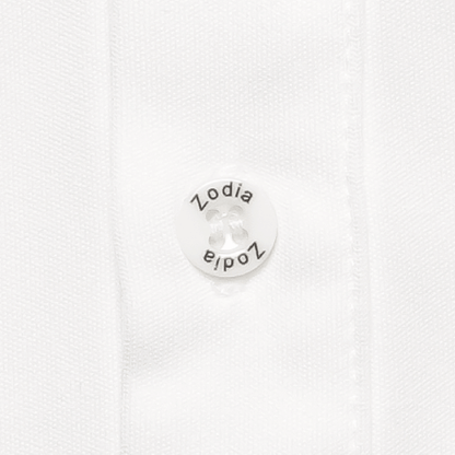 Close-up of Zodia Splash Polo Shirt button featuring the Zodia logo in white on a textured fabric background.