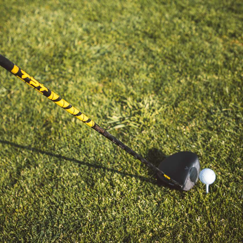 TPT Nitro Range Driver Shaft positioned next to a golf ball on grass, showcasing its performance and design.