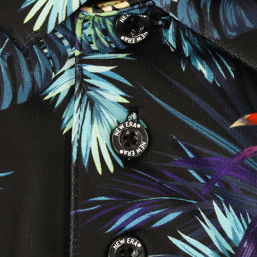 Close-up of the botanical print and buttons on the Zodia Botanical Polo Shirt in black fabric.