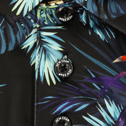Close-up of the botanical print and buttons on the Zodia Botanical Polo Shirt in black fabric.