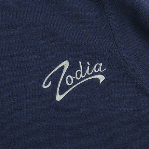 Zodia logo embroidered on a navy crewneck sweater fabric, showcasing stylish design and quality craftsmanship.