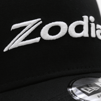 Zodia Metal Badge Cap featuring embroidered logo on a black cotton base, showcasing stylish design details.