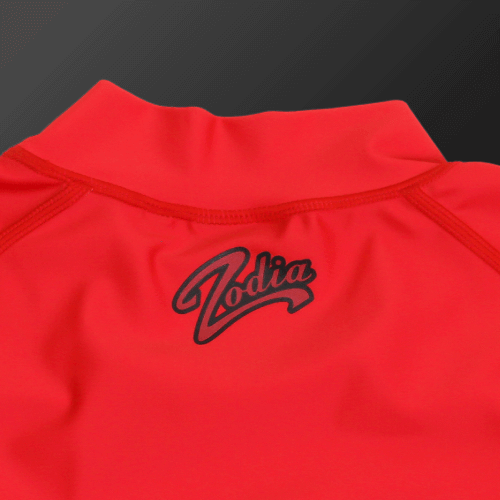Close-up of Zodia mock neck shirt in red with black logo, showcasing stylish design and stretchy fit.