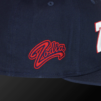 Zodia × NEW ERA navy flat visor cap showcasing red Zodia logo on the side, ideal for casual wear.