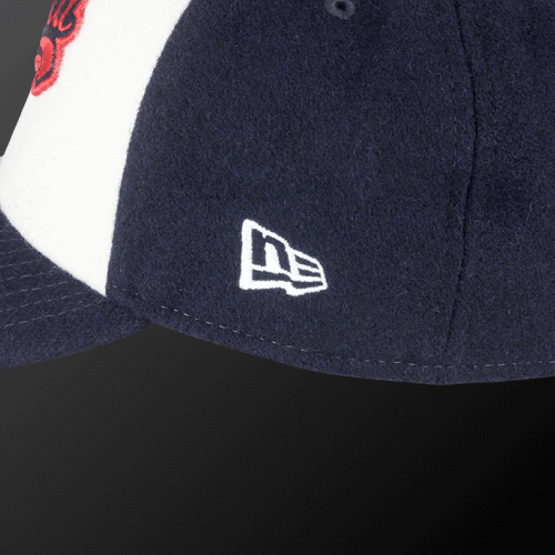 Close-up of Zodia × NEW ERA wool cap showcasing navy blue color and iconic logo detail.