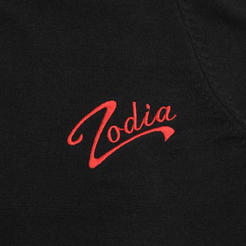Close-up of Zodia logo embroidered in red on a black fabric background.