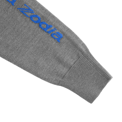 Detail of Zodia Zip-Up Sweater sleeve featuring blue logo on gray knit fabric, showcasing stylish design.