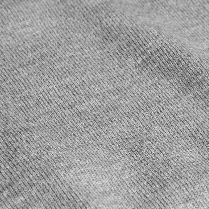 Close-up of a soft gray knit fabric, showcasing texture and weave details for the Zodia Zip-Up Sweater.