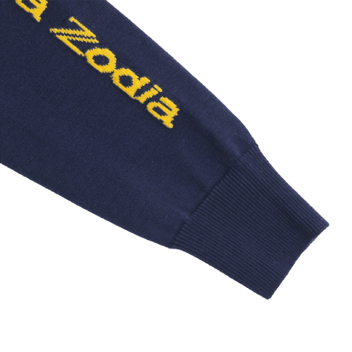 Close-up of Zodia Zip-Up Sweater sleeve featuring stylish yellow logo on navy knit fabric.