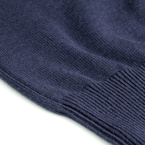 Close-up of the Zodia Zip-Up Sweater showcasing its soft navy knit texture and ribbed detailing.